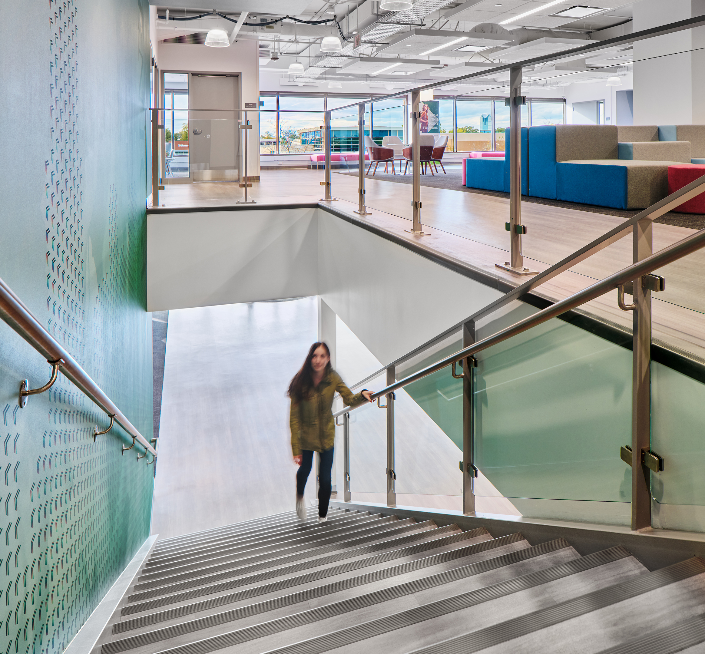Student walking up the main stairway of the Oak Point University's new Oak Brook campus